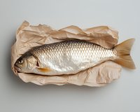 Fresh whole carp fish lying on crumpled kraft paper, top view. Raw seafood with silver scales on neutral background for food and culinary use.