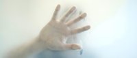 Translucent hand pressing against frosted glass surface, creating soft diffused silhouette effect for concepts of barriers, communication, and separation.