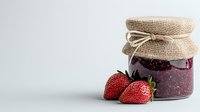 Fresh strawberry jam in glass jar with burlap lid and ripe berries on white background, homemade preserves for natural food photography and packaging design.