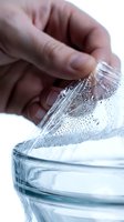 Close-up of a hand pouring fresh water into a glass, showing water droplets and splashing. Suitable for health, wellness, hydration and beverage concepts.