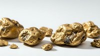 Gold nuggets scattered on white background showing natural metallic texture and rough surface formation for mining and precious metal concepts.