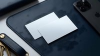 Blank white business cards mockup on dark leather desk pad with smartphone and keys for corporate branding and identity design projects.