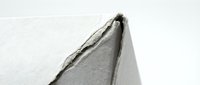 Torn gray fabric edge with frayed threads on white background, isolated textile material for fashion design projects and creative applications.