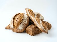 Freshly baked artisan bread loaves with crispy crust and flour dusting, isolated on white background for bakery, food, and culinary design projects.