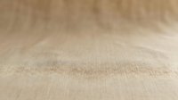 Natural beige linen fabric texture with soft weave pattern creating warm neutral background surface for product photography and design projects.