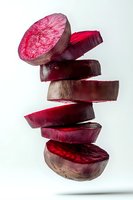 Fresh beetroot slices falling in dynamic stack showing vibrant purple interior and natural texture for healthy cooking and nutrition concepts.