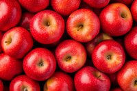 Fresh red apples with water drops background. Ripe whole fruits arranged in rows showing natural texture and vibrant color for healthy eating concept.