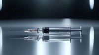 Medical syringe with needle on reflective surface in dramatic lighting, healthcare concept showing vaccination and medicine administration tools.