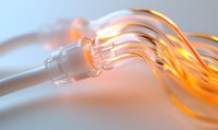 Glowing fiber optic cables emit orange light against soft blurred background, showcasing modern telecommunications and data transfer technology in macro view.