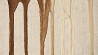 Organic brown and tan watercolor streaks dripping vertically on textured cream canvas, creating an abstract minimalist background suitable for web design, presentations, and creative projects.