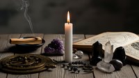 Mystical altar setup with burning candle, crystals, tarot cards, and incense for spiritual practices, meditation, and esoteric rituals on wooden table.