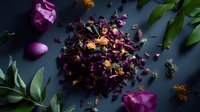 Dried purple rose petals and buds scattered on dark background with fresh green leaves, creating aromatic botanical composition for tea, potpourri and aromatherapy.