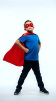 Young boy wearing superhero costume with red cape and mask standing confidently in power pose on white background for creative projects.
