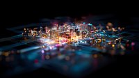 Glowing miniature cityscape rising from circuit board with illuminated buildings and digital connections creating futuristic technology concept in dark background.
