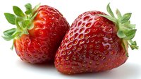 Fresh ripe strawberries with green leaves isolated on white background, showcasing vibrant red color and textured surface.