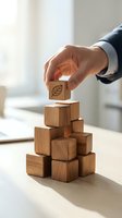 Businessman hand placing wooden block with leaf symbol on stack representing sustainable business growth and environmental responsibility concepts.