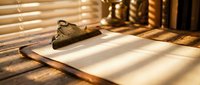 Vintage brass scales of justice on wooden desk with warm sunlight streaming through window blinds creating dramatic shadows for legal concepts.