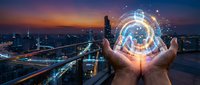 Hands holding glowing digital globe above cityscape at sunset, representing global technology, connectivity, and business innovation for corporate and digital transformation concepts.
