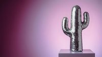 Silver metallic cactus sculpture on pedestal against purple gradient background for modern interior design and contemporary home decor concepts.