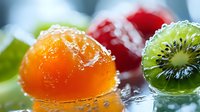 Fresh fruit jellies with orange and kiwi flavors covered in sparkling sugar crystals on white surface for dessert and confectionery concepts.