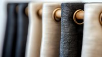 Modern curtains with metal grommets in neutral colors of black, gray and beige create elegant window treatment design, close up view showing texture and details.