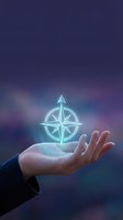 Businessman hand holding glowing compass rose symbol against purple blue gradient background representing navigation guidance and business direction.