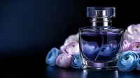 Luxury perfume bottle with elegant glass design surrounded by soft pink and blue roses on dark background for cosmetic advertising.