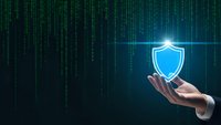 Digital cybersecurity concept with businessman hand holding glowing shield icon against matrix code background for data protection and network security.