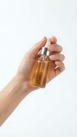 Hand holding amber serum bottle with dropper for skincare routine and beauty treatment on white background.