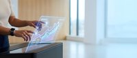 Businessman using futuristic holographic interface technology on tablet device in modern office environment for digital innovation and data visualization.