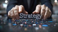 Businessman hands positioning strategy text over digital network, representing business planning and technological innovation in corporate decision-making.