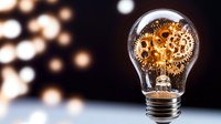 Light bulb with golden gears and cogs inside representing innovation, creativity and mechanical thinking against blurred bokeh background for business concepts.