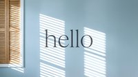 Soft blue wall with wooden shutters casting geometric shadows and the word hello in elegant typography.