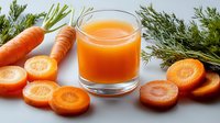 Fresh carrot juice in glass with sliced carrots and green dill on light background, healthy vegetable drink for detox and wellness program.