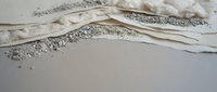 Gentle ocean waves washing onto sandy beach shore with white foam and bubbles creating peaceful coastal scenery for relaxation and vacation themes.