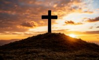 Christian cross silhouette on hilltop against dramatic orange sunset sky with glowing clouds, spiritual symbol of faith and hope for religious backgrounds.