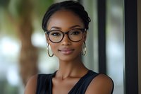 Professional African American businesswoman with glasses smiling confidently in modern office environment for corporate and career success concepts.