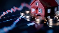 Real estate investment concept with miniature red house model and golden coins on financial chart background showing market trends and property value growth.