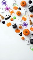 Halloween party decorations and toys scattered on white background with pumpkins, spiders, ghosts, witch hats and cauldrons for seasonal celebration design.
