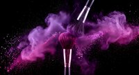 Professional makeup brushes with vibrant purple powder explosion against black background for cosmetic and beauty industry applications.