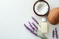 Fresh coconut halves with lavender sprigs and natural cosmetic oil bottle on white background, minimalist spa and wellness composition.