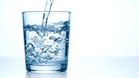 Fresh clean water pouring into transparent glass with dynamic splash and bubbles creating refreshing drink concept for healthy lifestyle and hydration.