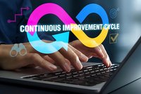 Business professional typing on laptop with colorful infinity symbol representing continuous improvement cycle for corporate development and optimization.