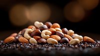 Mixed nuts almonds hazelnuts walnuts cashews healthy snack protein rich food pile scattered dark background warm bokeh lighting nutritious eating.