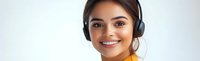 Young Hispanic woman wearing wireless headphones and orange top smiling at camera against light background, representing online learning and modern lifestyle.