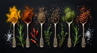 Colorful assortment of spices and herbs in vintage spoons on dark background, top view flat lay for culinary and food design.