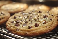 Freshly baked chocolate chip cookies cooling on wire rack with golden brown edges and melted chocolate chips for baking and dessert concepts.