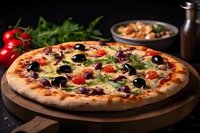 Fresh homemade pizza with melted cheese, black olives, cherry tomatoes and herbs on wooden board, dark rustic background with ingredients.