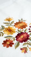 Colorful embroidered flowers with leaves on white fabric showcasing traditional needlework craftsmanship and textile art techniques for handmade projects.