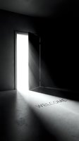 Open door with bright light streaming into a dark room, casting the word WELCOME on the floor, symbolizing opportunity and new beginnings.